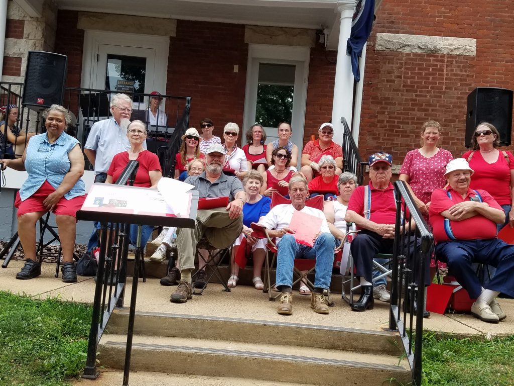 A group of people sitting on steps outside.