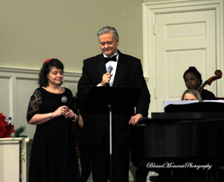 A man and woman are singing at an event.